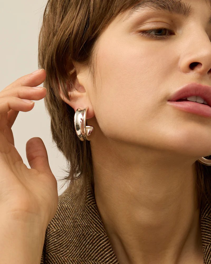 Jenny Bird doune hoops in high polish silver styled on model.