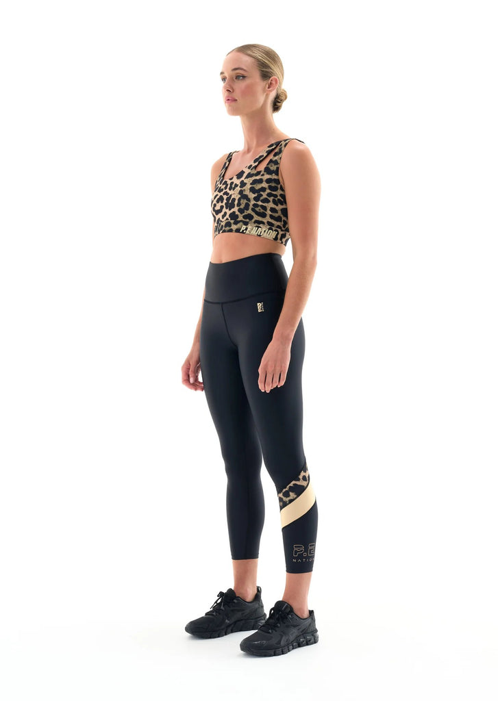 p.e. nation alignment legging in black model gold stripe colorblock detail side view