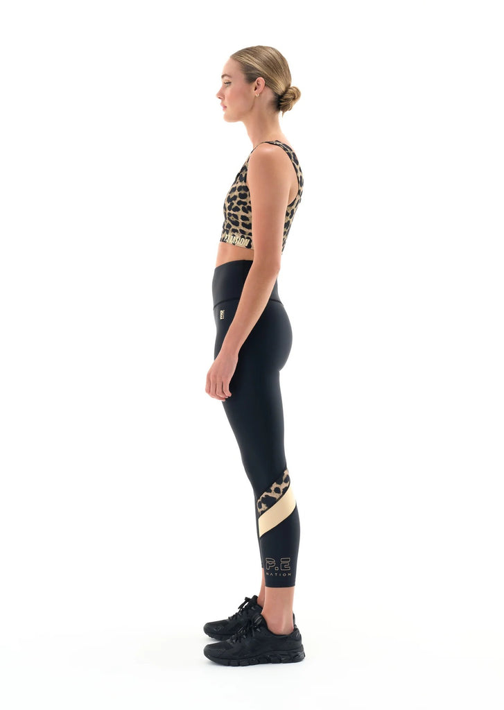 p.e. nation alignment legging in black model gold stripe colorblock side view