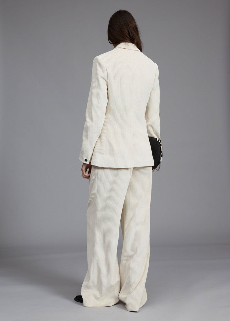 rag and bone tessa blazer in ivory styled on model with matching ivory pants behind view.